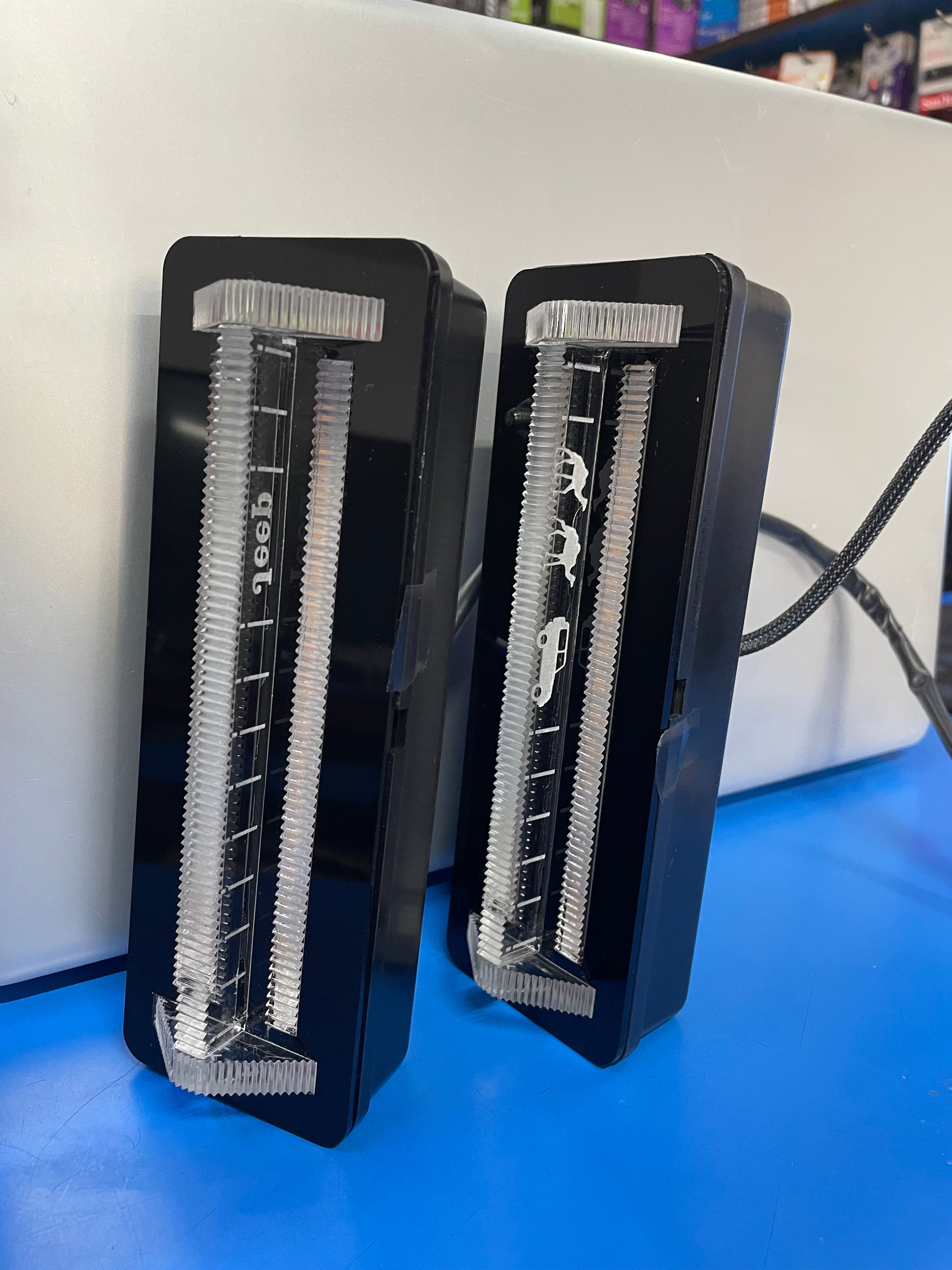 Two black electric shaver heads on a white surface with a blue background