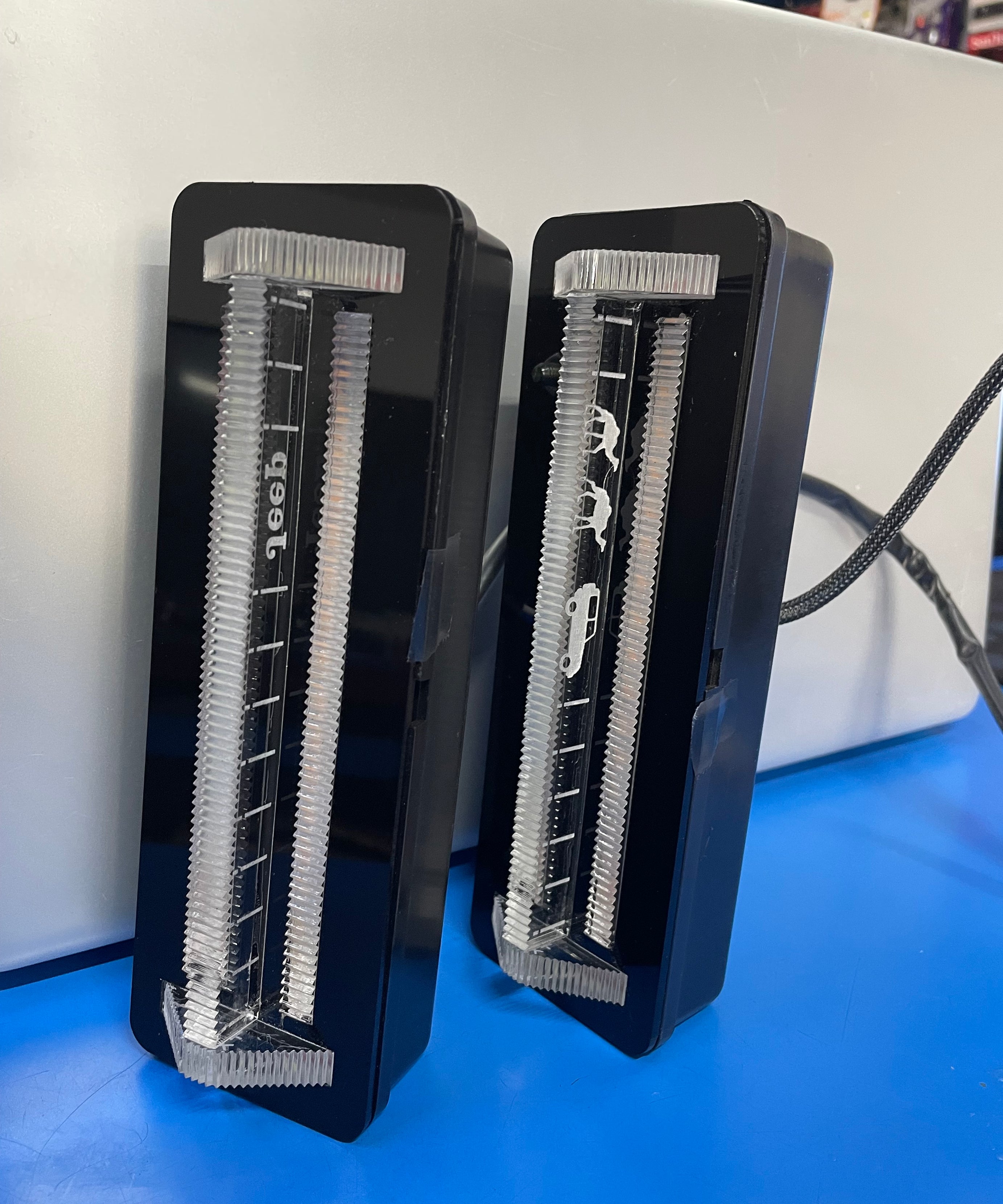 Two black electric shaver heads on a white surface with a blue background
