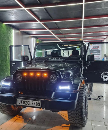 Black off-road vehicle with visible license plate in a showroom setting
