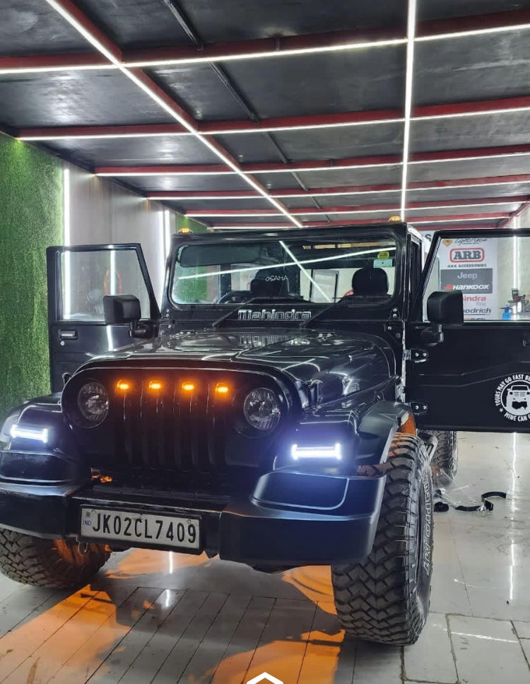 Black off-road vehicle with visible license plate in a showroom setting
